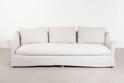 une photo d'un canapé blanc orné de coussins dans une pièce