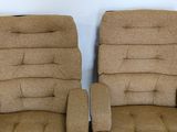 two brown recliners are sitting side by side against a white wall