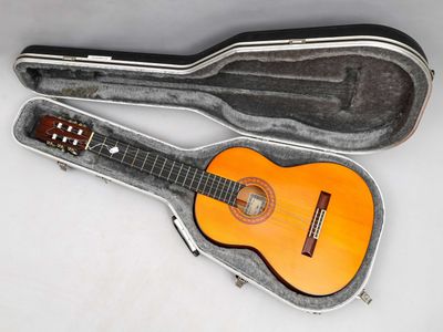 une image représentant une guitare dans son étui, posée sur une surface blanche