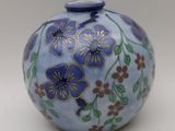 a blue vase with flowers on it sitting on a table