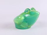 a green frog figurine sitting on a white surface