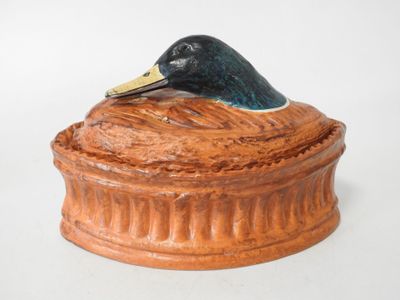 a ceramic duck sitting on top of a box