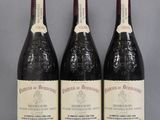 three bottles of wine are lined up on a table
