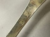 a silver spoon with a silver handle on a table