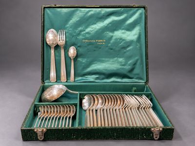 un coffret vert contenant de l'argenterie sur une table