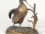 a bronze statue of a bird on a branch