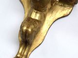 a gold statue of a man laying on a pillow
