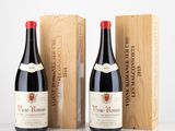Deux bouteilles de vin sont posées à côté d'une caisse en bois sur une table.