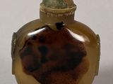 a small glass bottle with a lid on a table