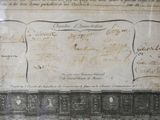 an old document with writing on it in a glass case