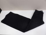 the black jeans are laying on the white table
