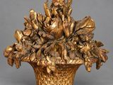 un vase en or contenant des fleurs, posé sur une table