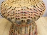 a wicker bowl on a wooden table with a white wall in the background