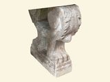 a stone sculpture of a head on a pedestal