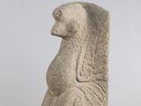 une statue antique représentant une femme assise sur une chaise