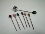 five spoons and a spoon with flowers on them sitting on a table