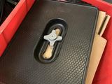 a red box with a black tray with a handle on it