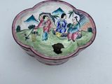 a small bowl with a painting on it sitting on a table