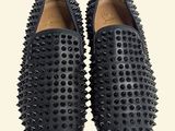 black spiked slippers on a white background