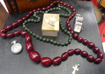 un collier et une montre posés sur une table à côté d'une boîte