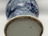 a blue and white vase sitting on a white surface