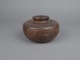 an old wooden bowl with a lid sitting on a table