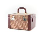 une image représentant une valise marron et beige munie de poignées, sur fond blanc