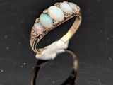 une bague en oplite et diamant posée sur un fond noir