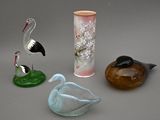 trois oiseaux en verre et un vase posés sur une table