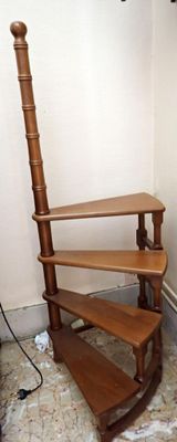 an image of a corner of a room with a chair and bookshelf