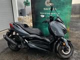 the motorcycle is parked in front of a building near a sign