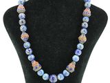 un collier composé de perles de verre bleues, présenté sur un mannequin noir