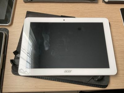 une tablette posée sur un bureau, à côté d'un clavier