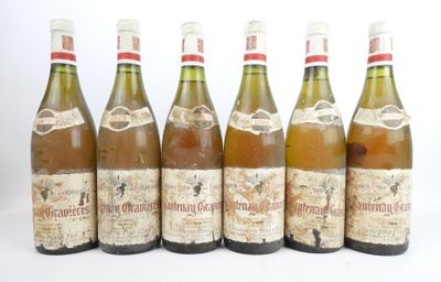 six bouteilles de vin posées les unes à côté des autres sur une surface blanche