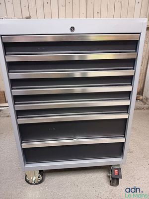 a close up of a metal tool cabinet on wheels in a garage