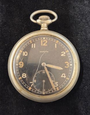 une montre de poche en or posée sur une surface noire