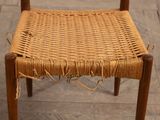 a wooden chair with a woven seat on a tile floor