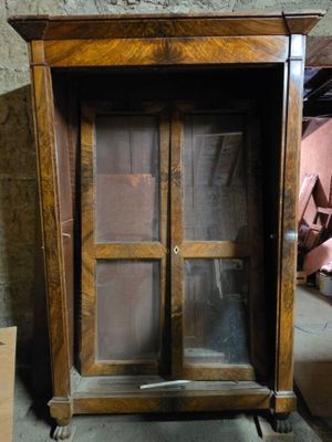 un meuble en bois avec une porte en verre au milieu d'une pièce
