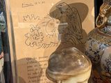 deux vases posés sur une table, avec un tableau derrière eux