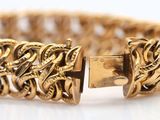 an image of a close up of a gold bracelet on a white surface