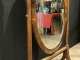 a mirror that is sitting on a stand on the floor