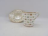a small cup and saucer sitting on a table