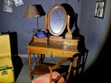 a desk with a mirror and a chair in a room