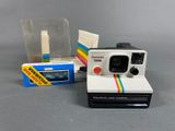 an image of a polaroid camera with a box of film next to it