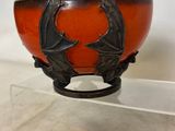 a close up of a bowl on a stand on a table