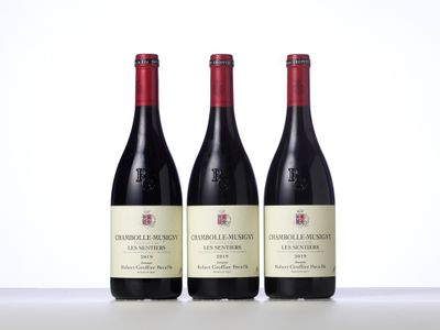 trois bouteilles de vin rouge sont alignées sur une table