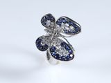 a close up of a ring with blue and white stones