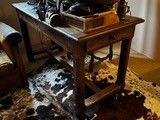 une table sur laquelle se trouvent un tapis en peau de vache et un vase contenant une plante