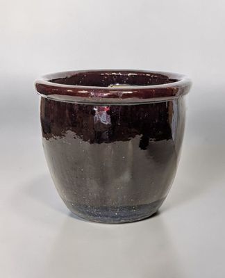 un bol noir et blanc posé sur une surface blanche