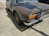 an old car that is parked in a lot